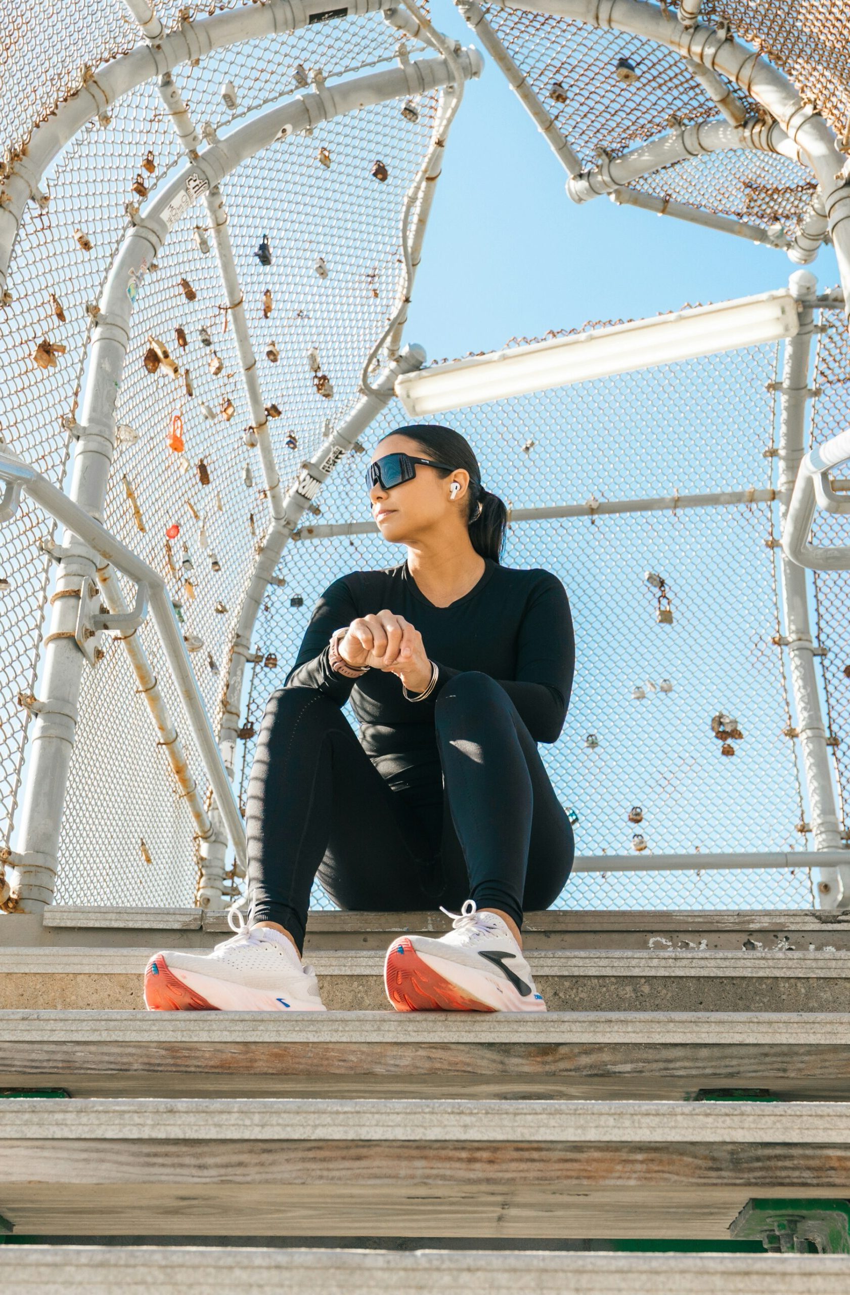 Woman in athletic wear sitting on outdoor stairs